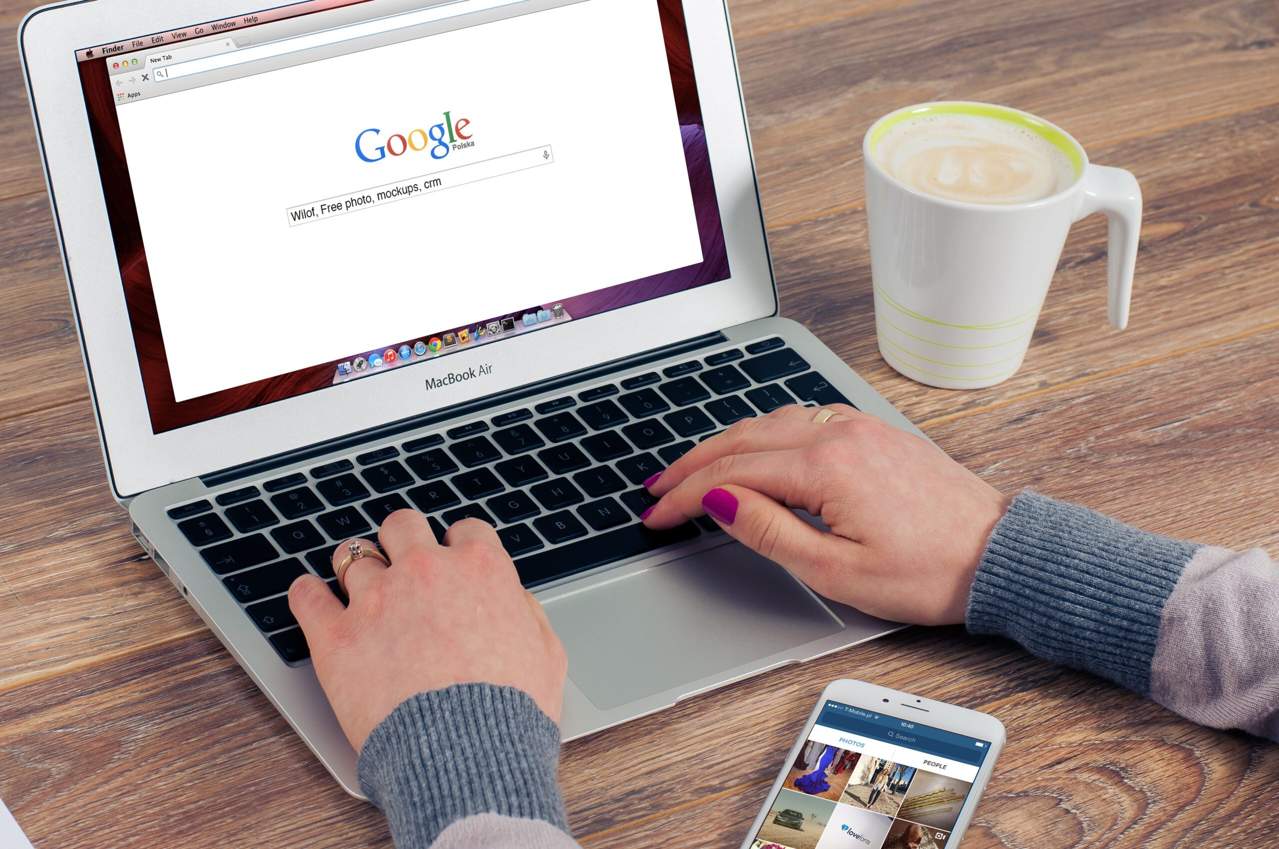 Kobieta wpisująca hasło w wyszukiwarkę Google otwartą na laptopie